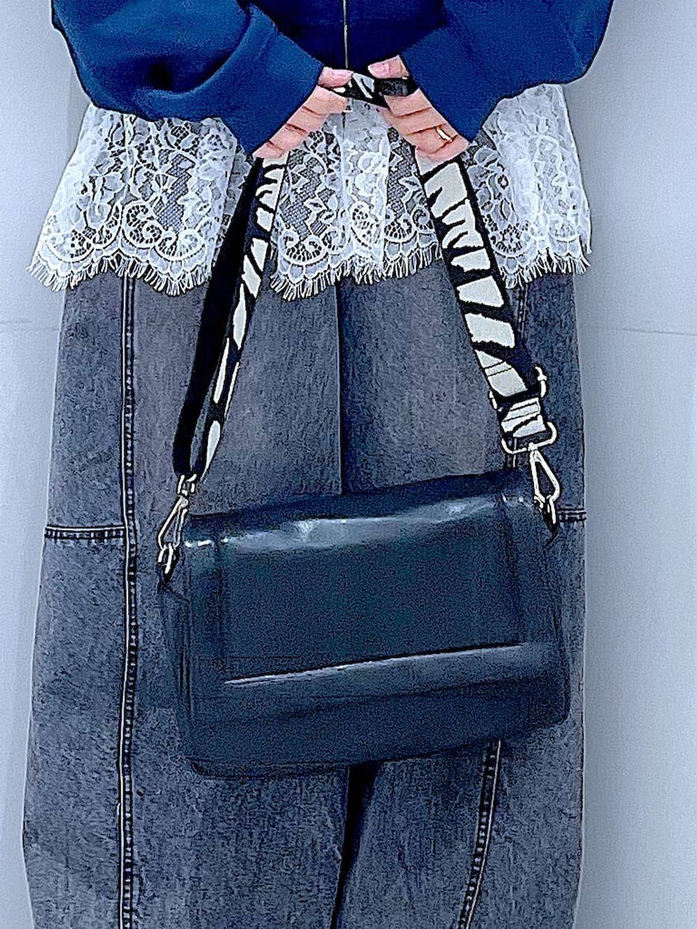 ブラック系のショルダーバッグ、ホワイト系のTシャツ/カットソー、ブラック系のデニムパンツを着用したレディースの春コーディネートの9枚目の写真