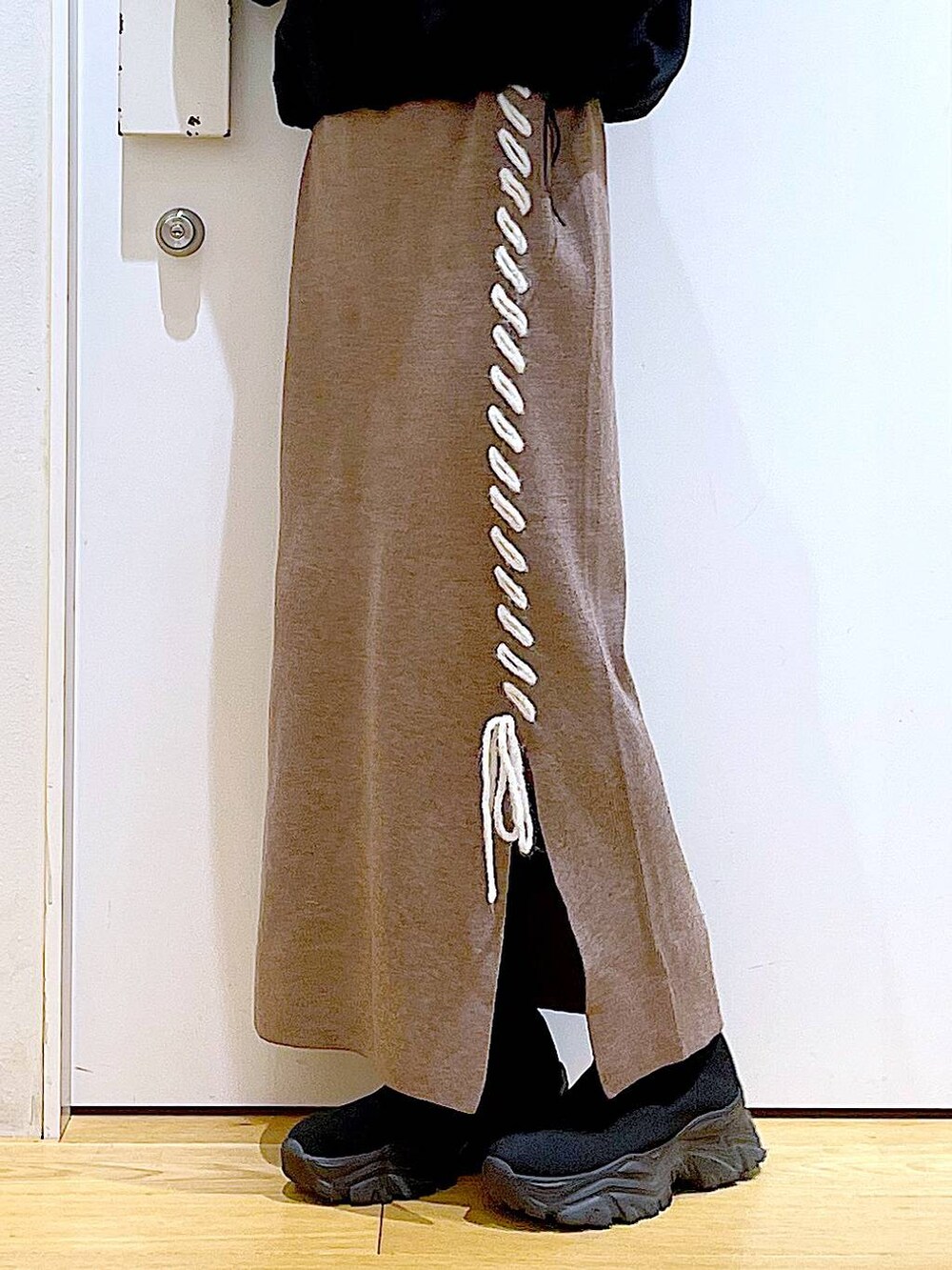 ブラック系のブーツ、ブラウン系のスカート、ブラック系のスウェットを着用したレディースの冬コーディネートの8枚目の写真