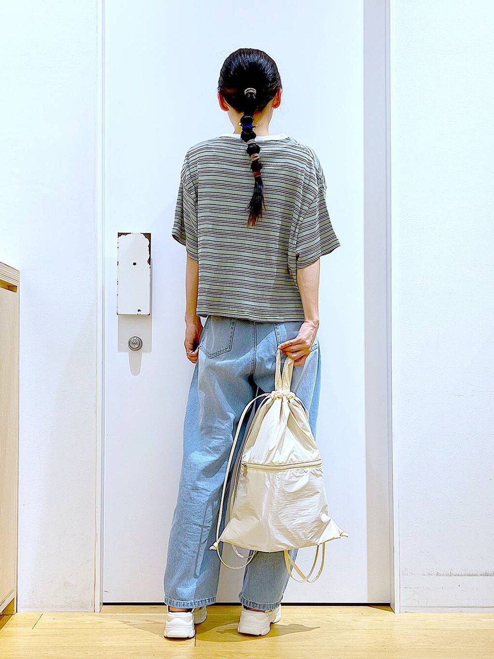 ホワイト系のバックパック/リュック、ホワイト系のサンダル、ブルー系のデニムパンツを着用したレディースの夏コーディネートの5枚目の写真