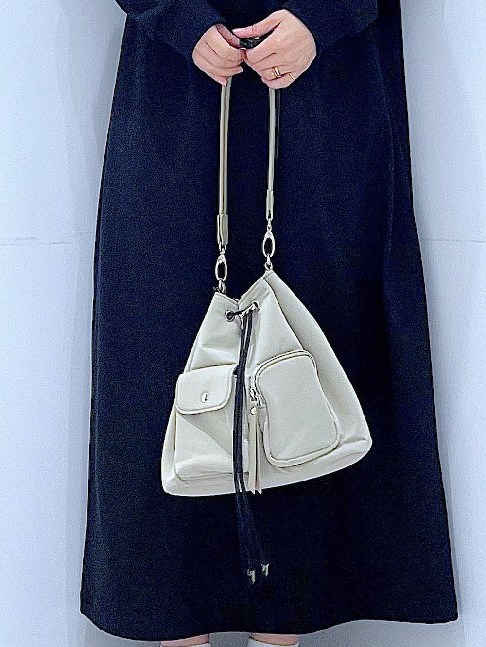 ホワイト系のショルダーバッグ、ブラック系のワンピース、ホワイト系のキャップを着用したレディースの春コーディネートの9枚目の写真