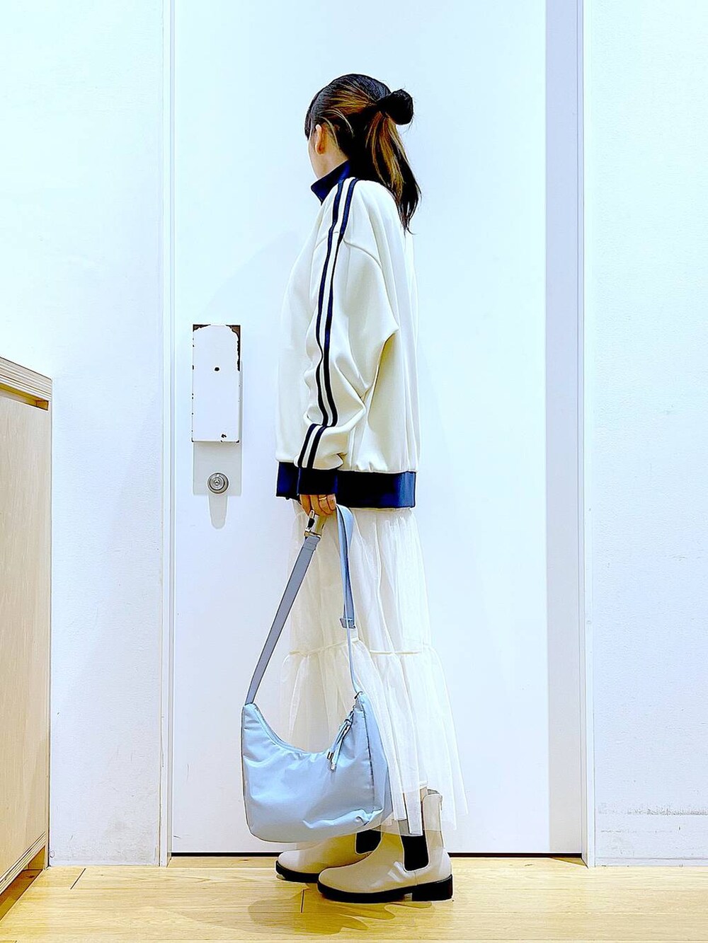 ベージュ系のブーツ、ブルー系のショルダーバッグ、ベージュ系のスウェットを着用したレディースの春コーディネートの3枚目の写真