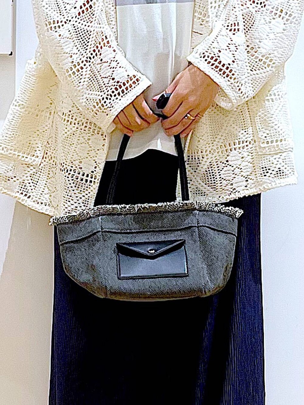 ブラック系のパンプス、ブラック系のショルダーバッグ、ホワイト系のテーラードジャケットを着用したレディースの春コーディネートの9枚目の写真