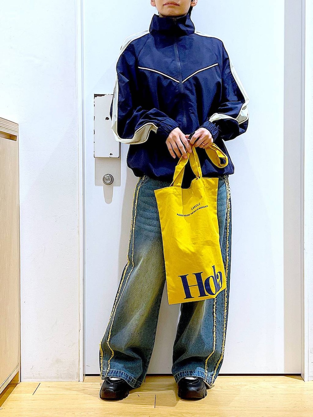 ブラック系のスニーカー、ブルー系のデニムパンツ、ブルー系のブルゾンを着用したレディースの春コーディネートの6枚目の写真
