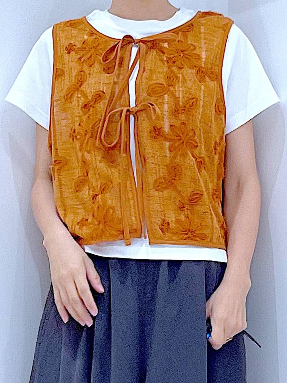 ホワイト系のTシャツ/カットソー、ホワイト系のショルダーバッグ、オレンジ系のベストを着用したレディースの夏コーディネートの7枚目の写真