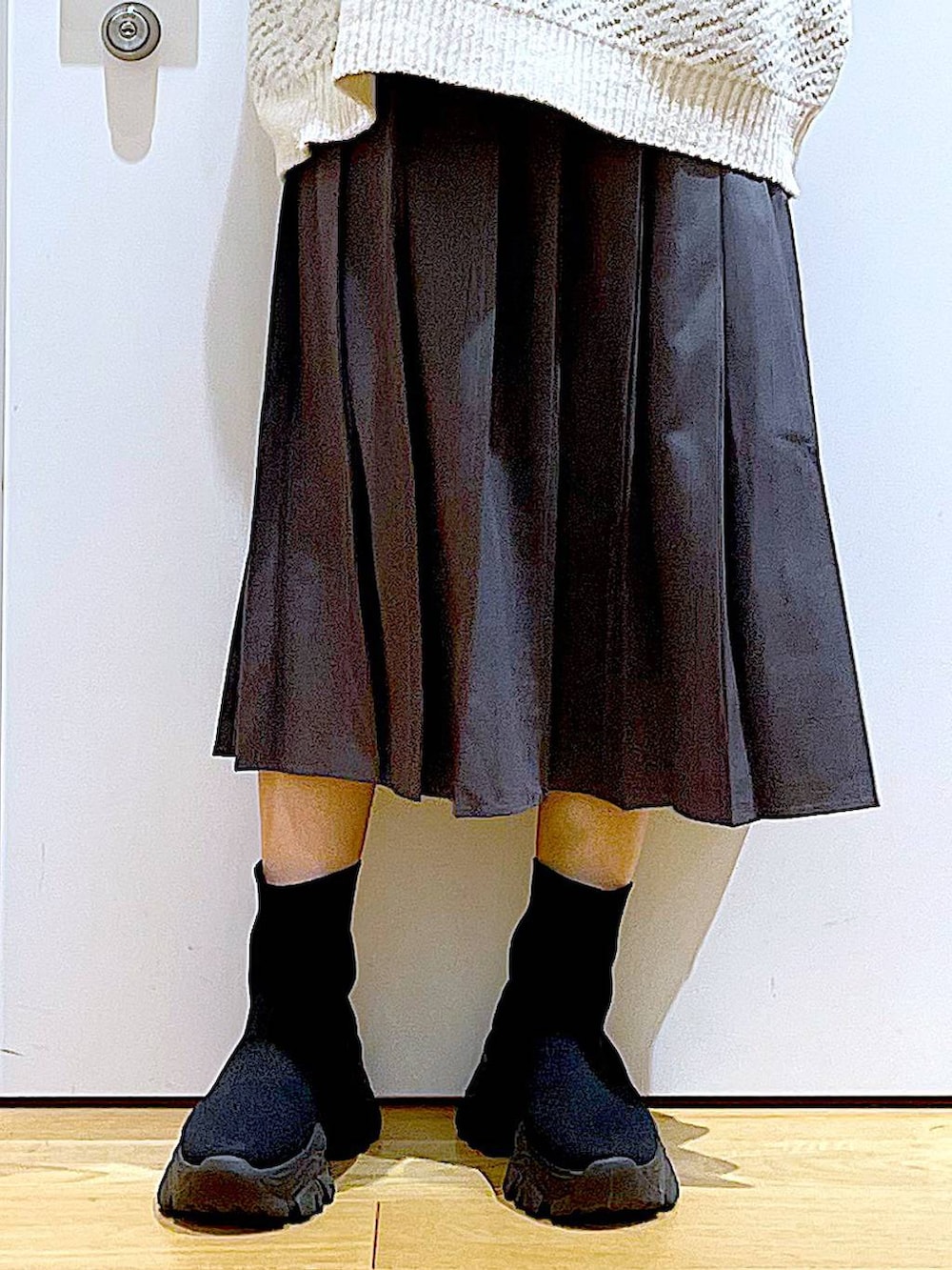 ベージュ系のニット/セーター、ピンク系のショルダーバッグ、ブラック系のブーツを着用したレディースの冬コーディネートの8枚目の写真