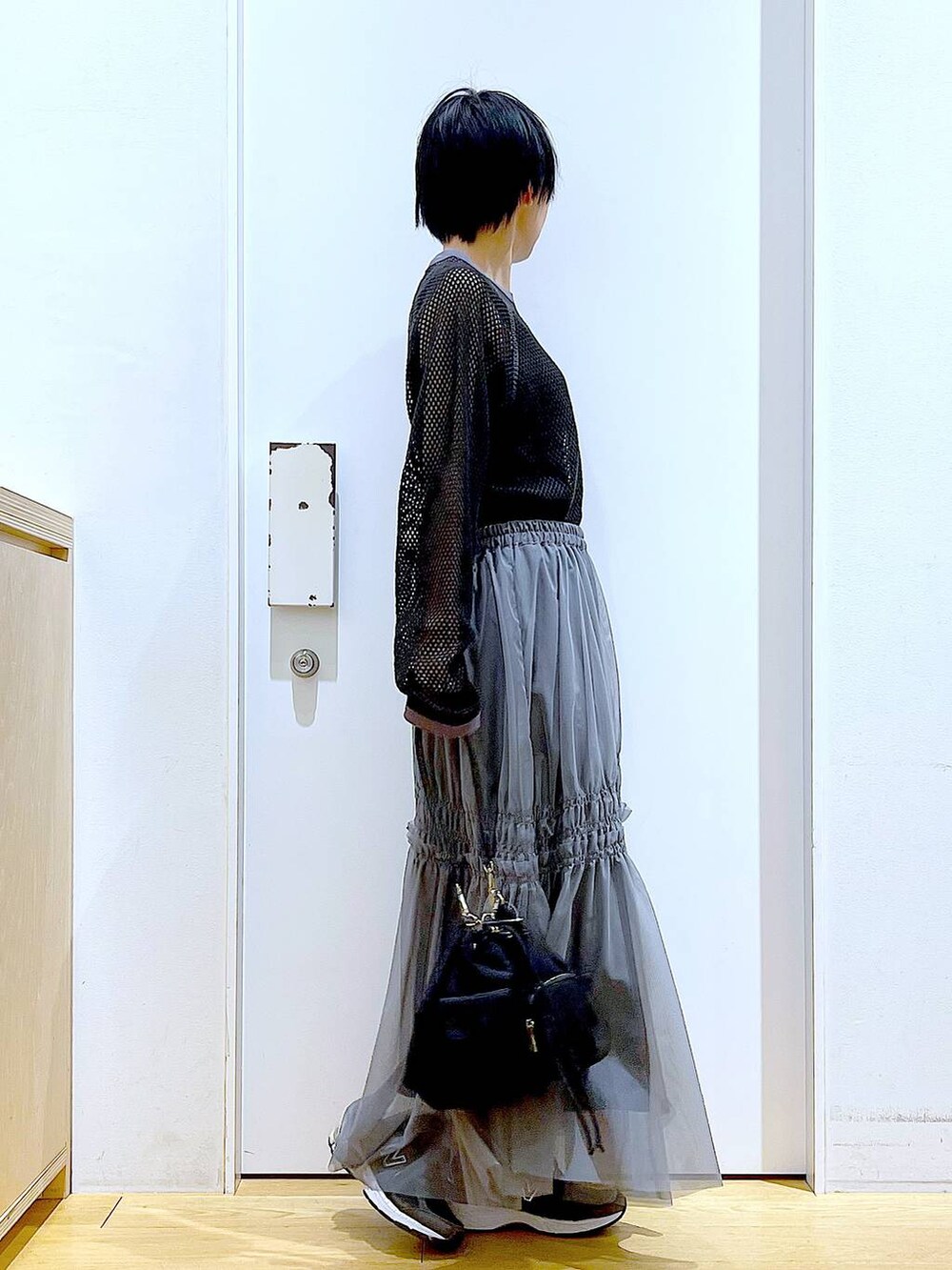 ブラック系のTシャツ/カットソー、グレー系のスカートを着用したレディースの春コーディネートの4枚目の写真