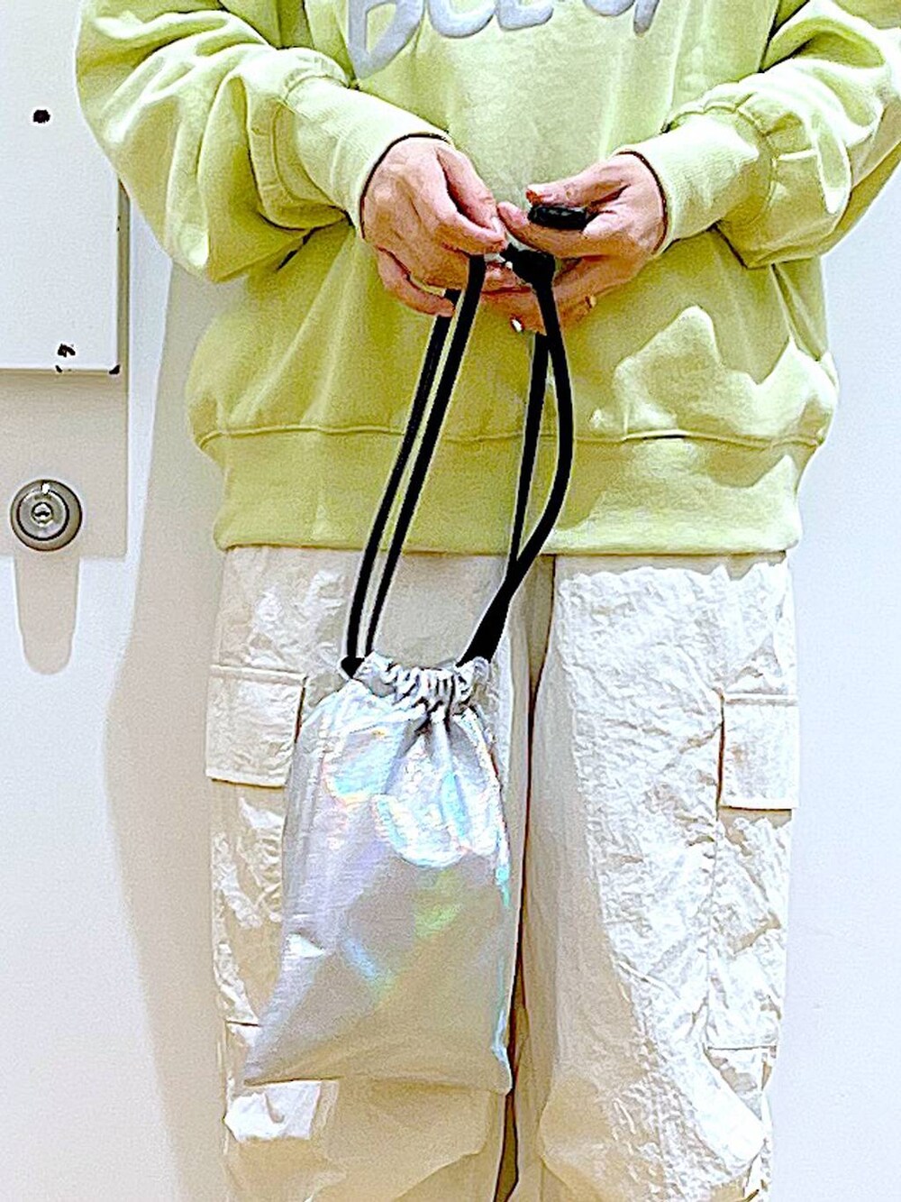 イエロー系のスウェット、ベージュ系のブーツ、その他のショルダーバッグを着用したレディースの春コーディネートの9枚目の写真