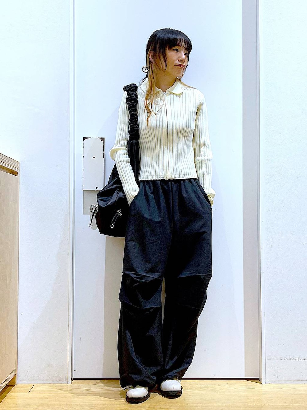 ブラック系のその他パンツ、ベージュ系のカーディガン/ボレロ、ベージュ系のブーツを着用したレディースの春コーディネートの2枚目の写真