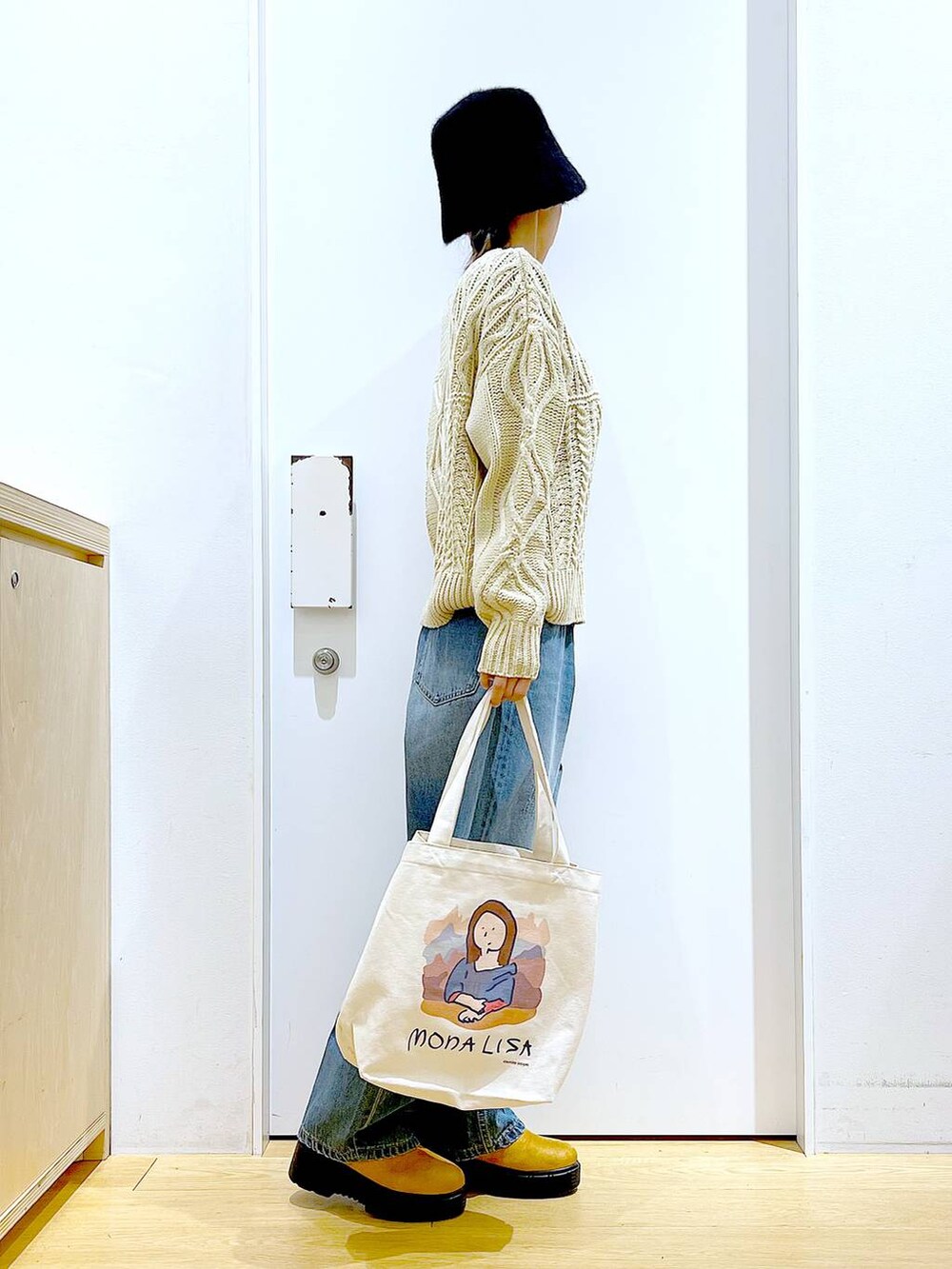 その他のトートバッグ、ブルー系のデニムパンツ、ベージュ系のブーツを着用したレディースの冬コーディネートの4枚目の写真