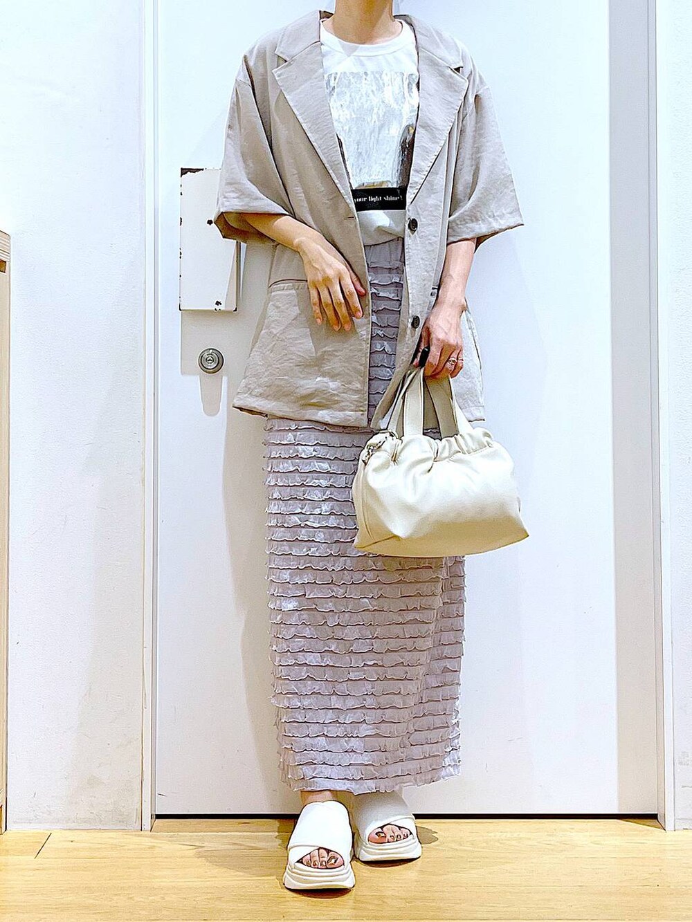 ホワイト系のサンダル、ホワイト系のショルダーバッグ、ホワイト系のTシャツ/カットソーを着用したレディースの夏コーディネートの6枚目の写真