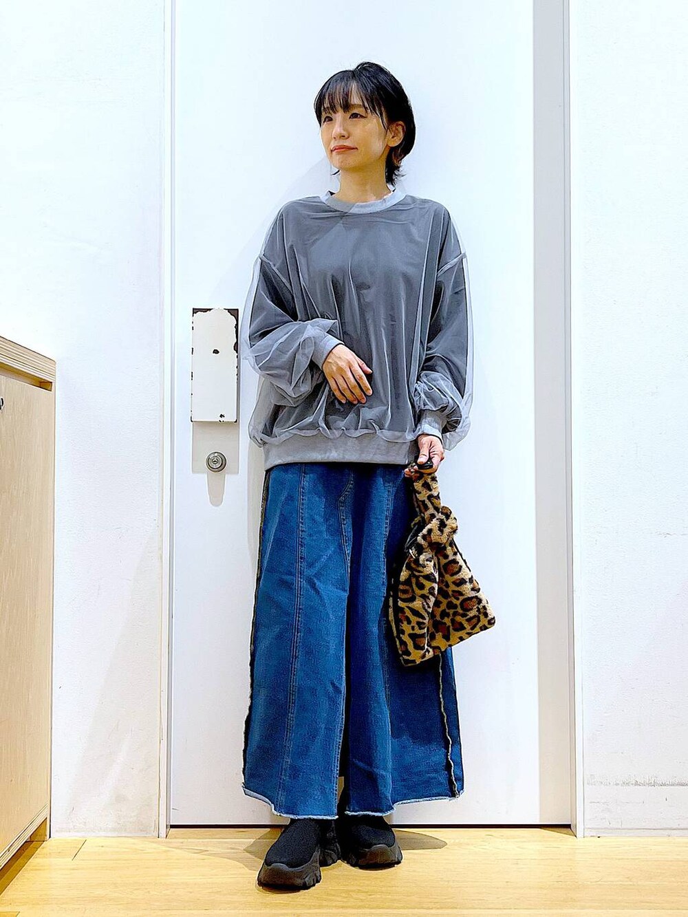 その他のショルダーバッグ、ブルー系のデニムスカート、ブラック系のブーツを着用したレディースの冬コーディネートの2枚目の写真