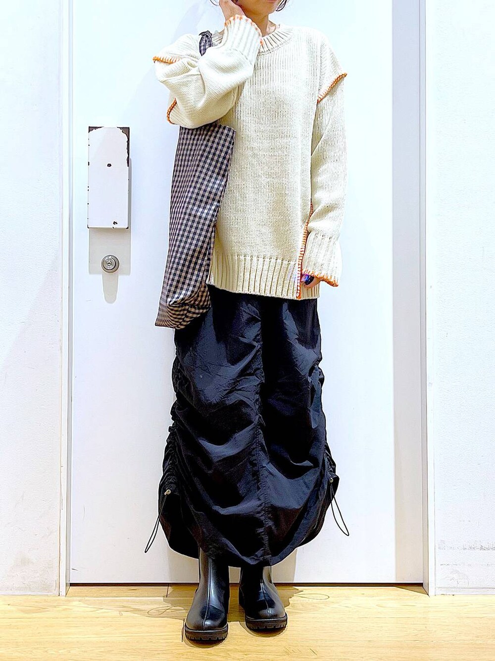 ブラック系のブーツ、その他のトートバッグ、ブラック系のスカートを着用したレディースの冬コーディネートの6枚目の写真