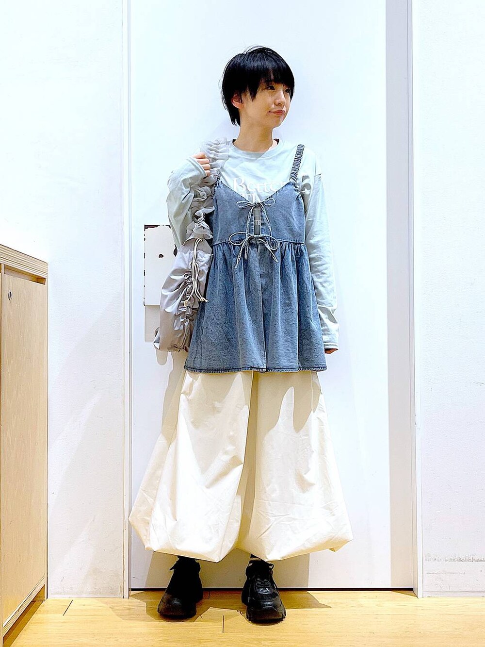 グレー系のショルダーバッグ、ブラック系のスニーカー、ブルー系のその他トップスを着用したレディースの春コーディネートの2枚目の写真