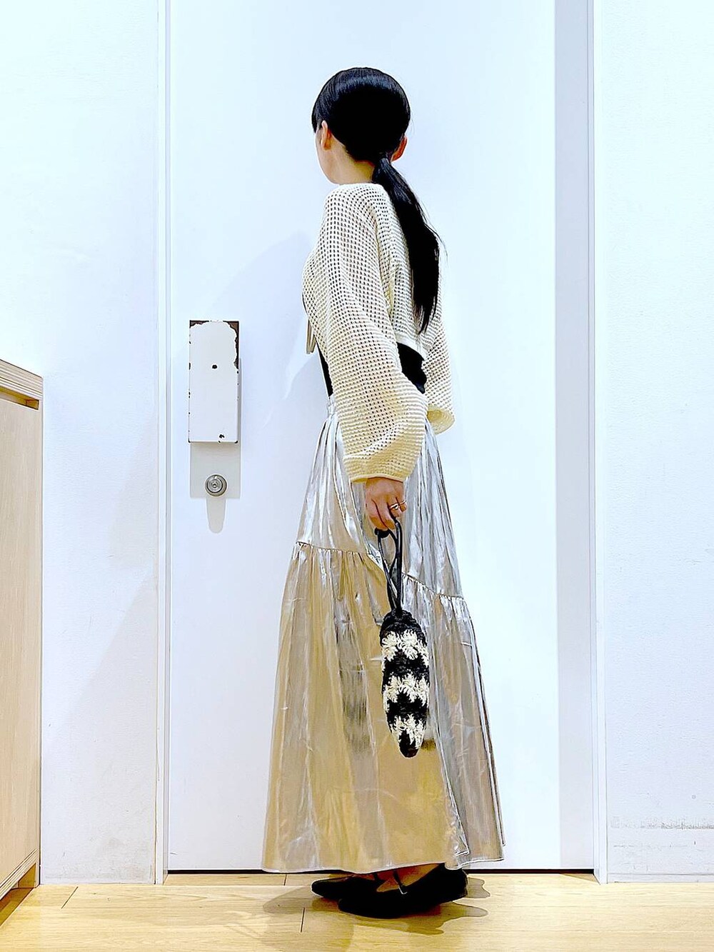 ホワイト系のカーディガン/ボレロ、ブラック系のパンプス、ブラック系のショルダーバッグを着用したレディースの夏コーディネートの3枚目の写真