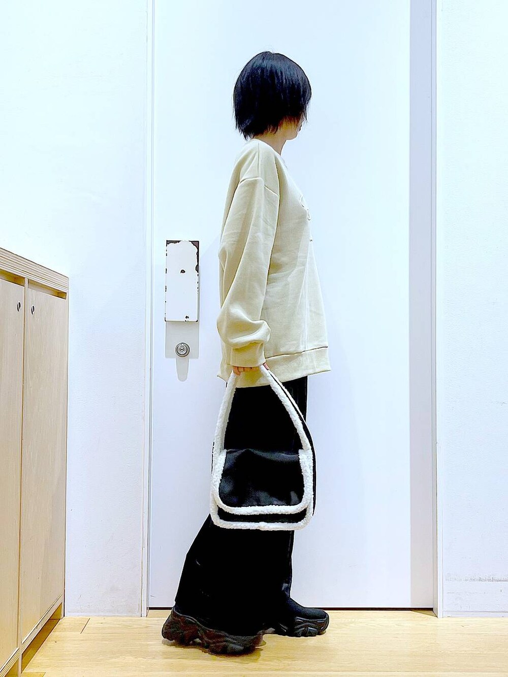 ブラック系のブーツ、ブラック系のショルダーバッグ、ブラック系のスカートを着用したレディースの冬コーディネートの4枚目の写真