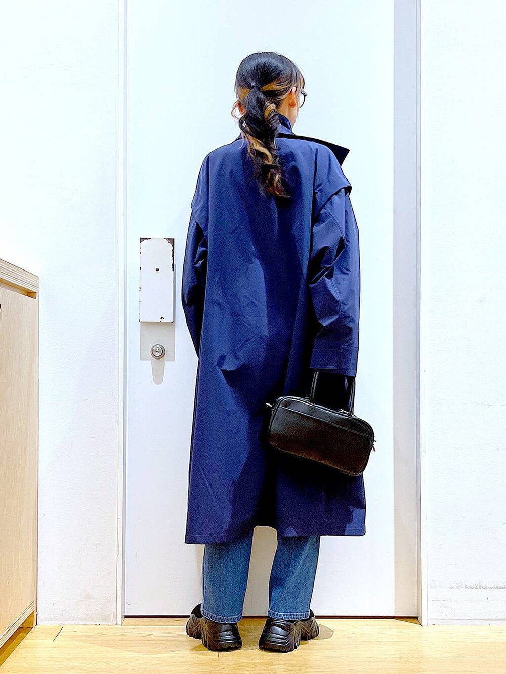 ブラック系のショルダーバッグ、ブルー系のデニムパンツ、ブルー系のその他アウターを着用したレディースの冬コーディネートの5枚目の写真