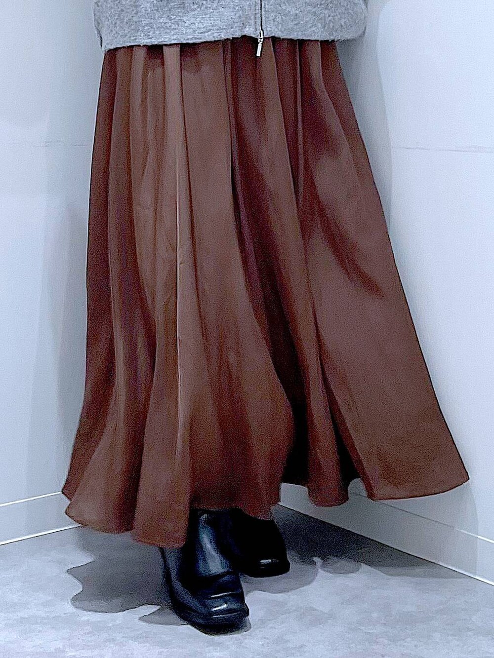 グレー系のブルゾン、ブラック系のブーツ、レッド系のショルダーバッグを着用したレディースの冬コーディネートの8枚目の写真