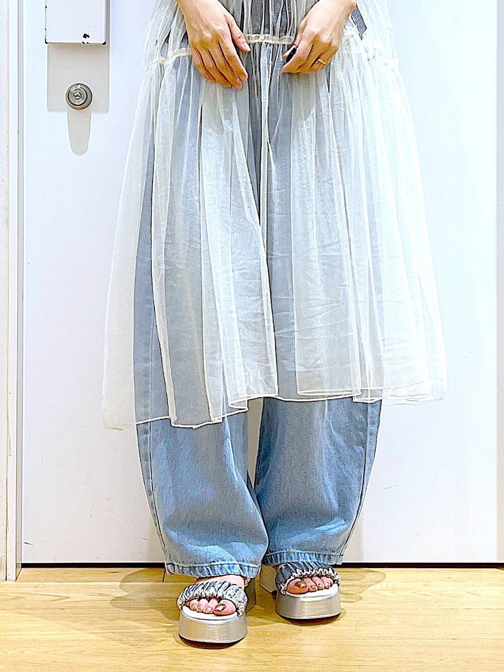 ブルー系のデニムパンツ、ホワイト系のショルダーバッグ、ブラック系のTシャツ/カットソーを着用したレディースの夏コーディネートの8枚目の写真