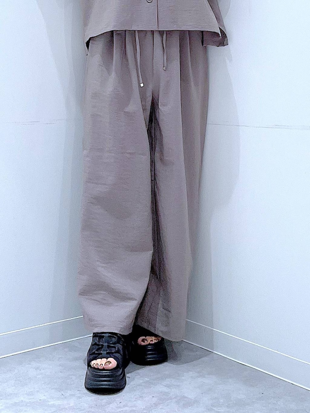 ブラック系のサンダル、ブラウン系のその他パンツ、ブラウン系のシャツ/ブラウスを着用したレディースの夏コーディネートの8枚目の写真