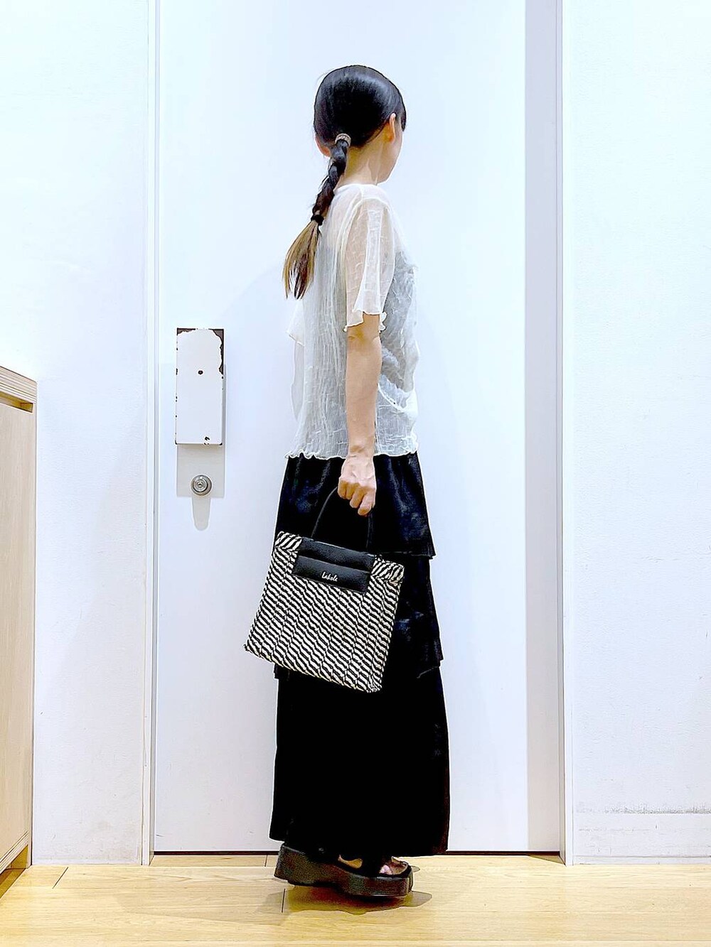 ブラック系のサンダル、ブラック系のショルダーバッグ、ブラック系のスカートを着用したレディースの夏コーディネートの4枚目の写真