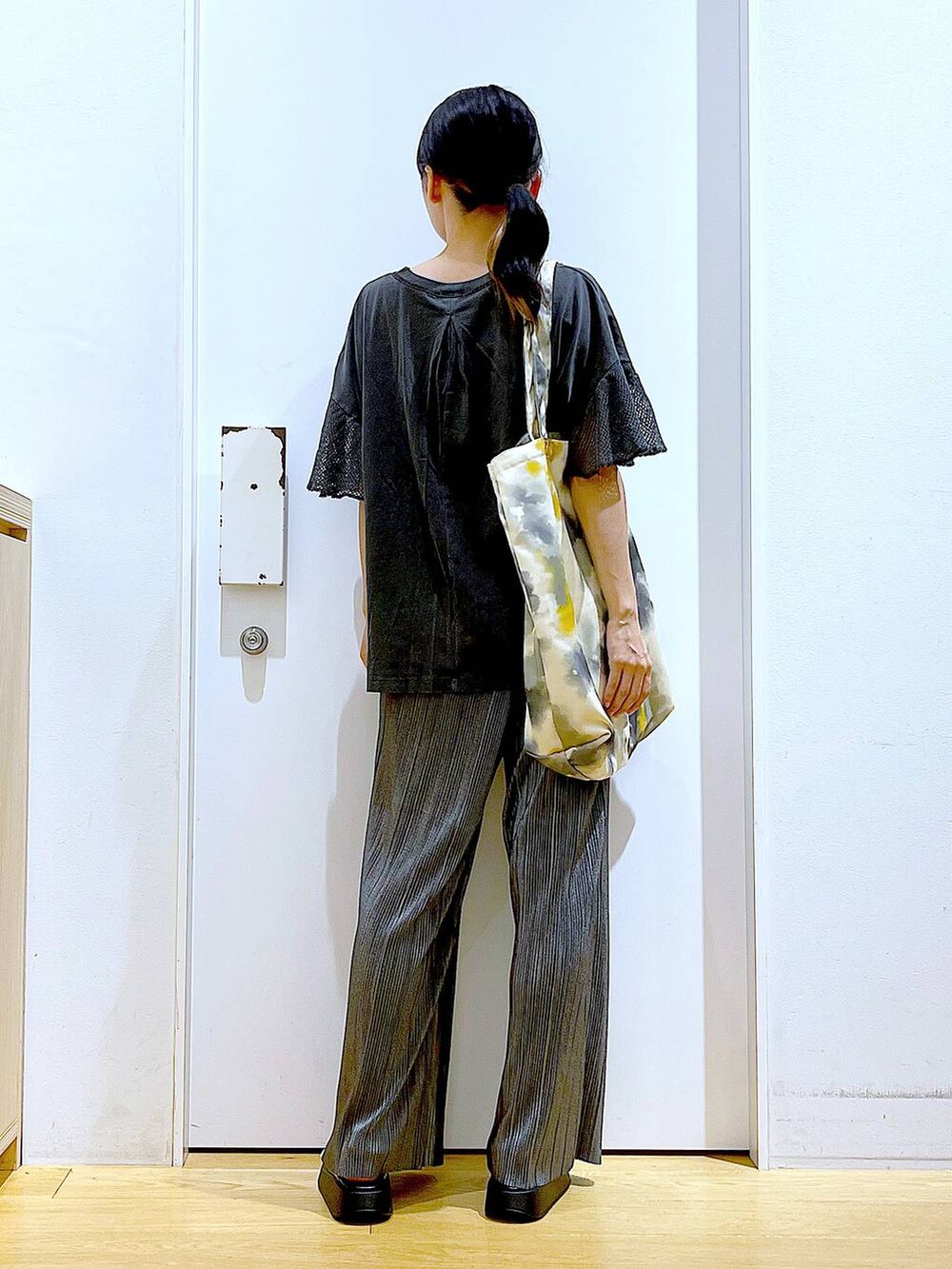 ホワイト系のサンダル、イエロー系のトートバッグ、グレー系のその他パンツを着用したレディースの秋コーディネートの5枚目の写真