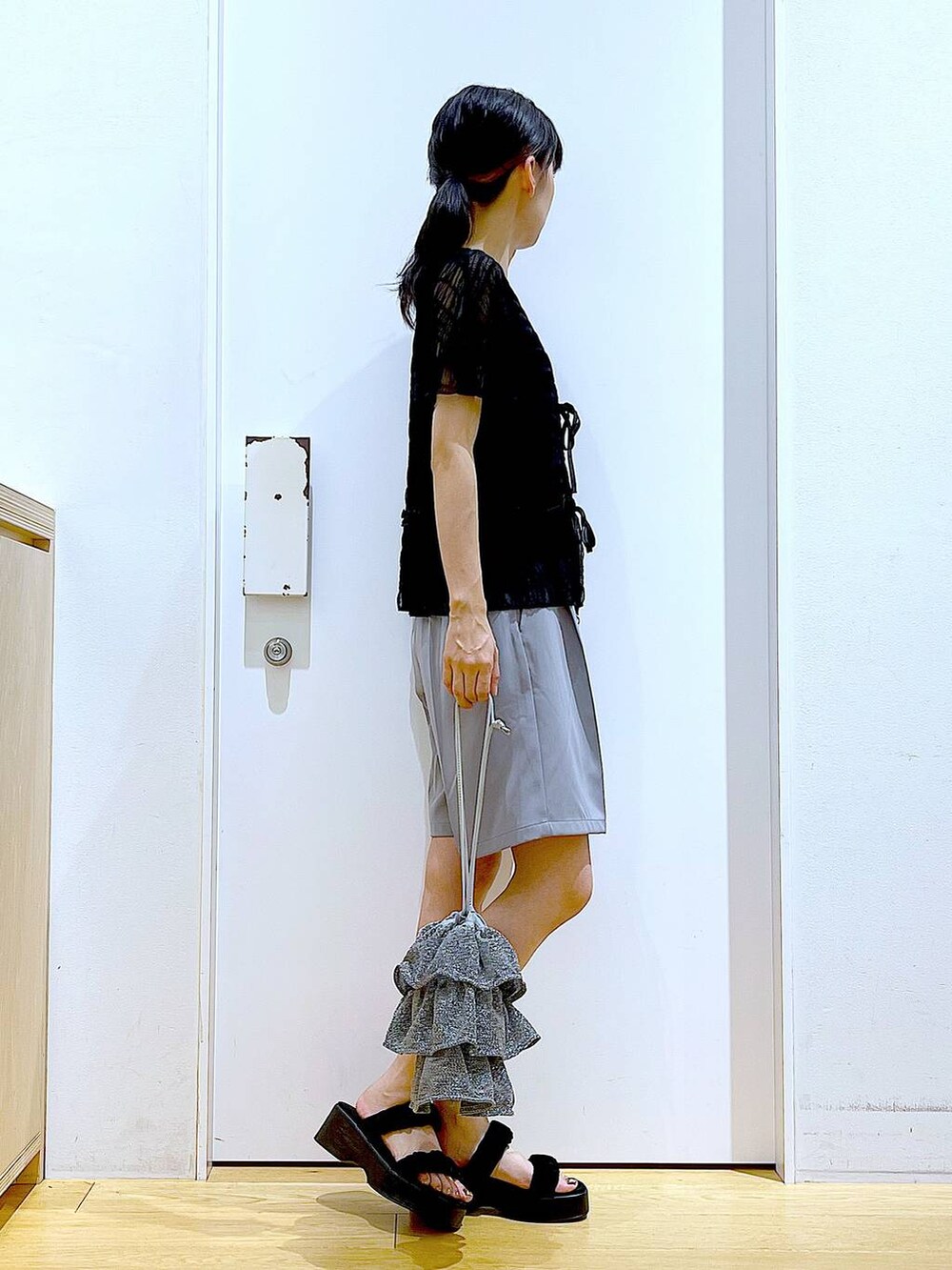 シルバー系のショルダーバッグ、グレー系のその他パンツ、ブラック系のサンダルを着用したレディースの夏コーディネートの4枚目の写真