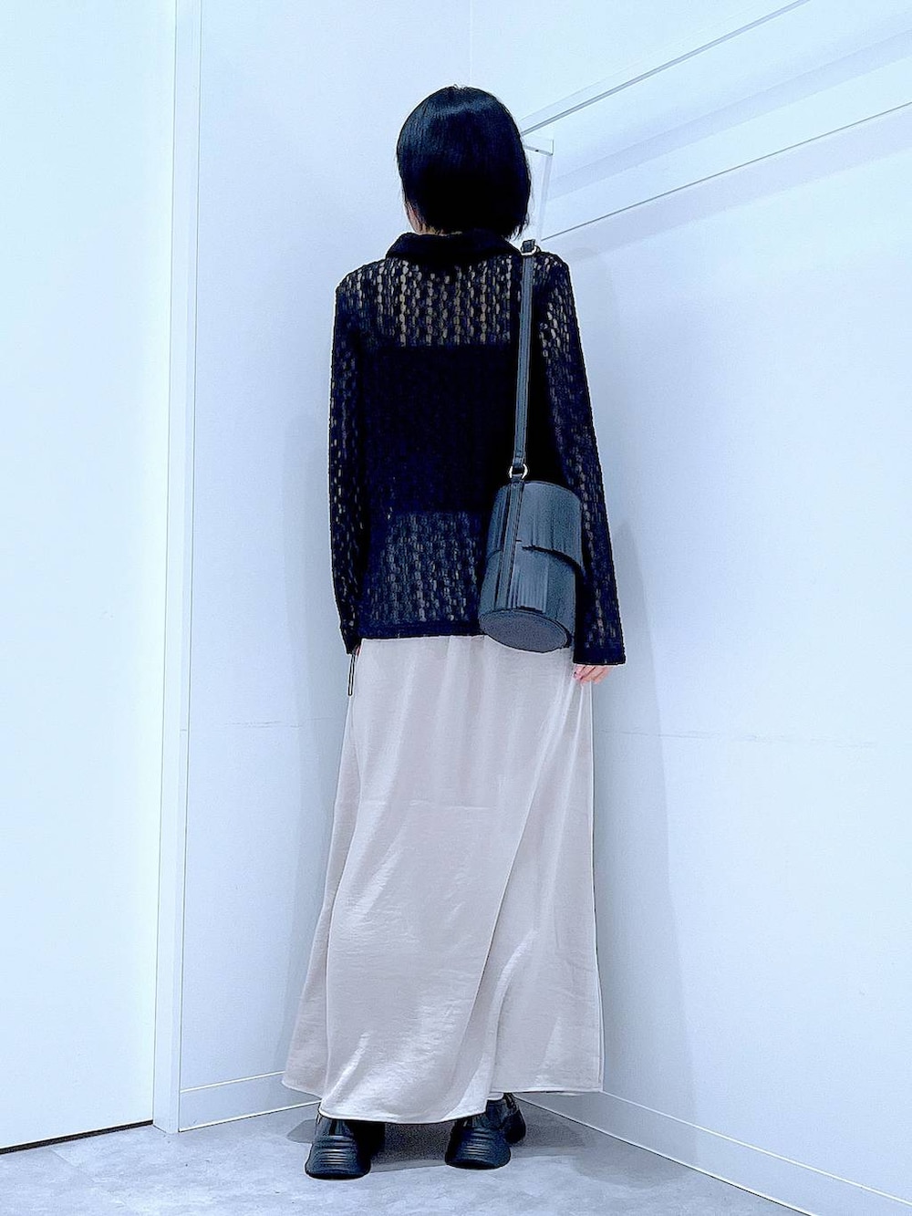 ブラック系のローファー、ブラック系のショルダーバッグ、ベージュ系のスカートを着用したレディースの秋コーディネートの5枚目の写真