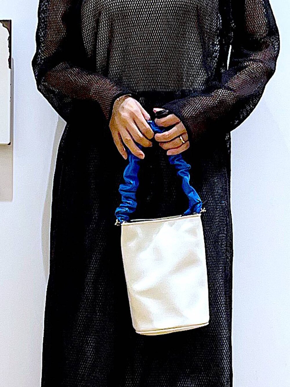 ブルー系のショルダーバッグ、ブラック系のパンプス、ブルー系のデニムパンツを着用したレディースの春コーディネートの9枚目の写真