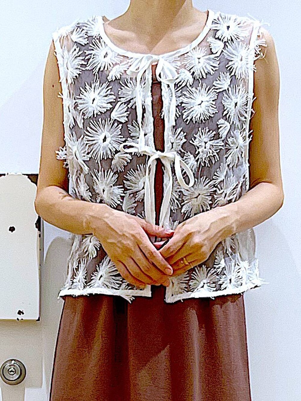 ホワイト系のサンダル、レッド系のワンピース、ホワイト系のベストを着用したレディースの夏コーディネートの7枚目の写真