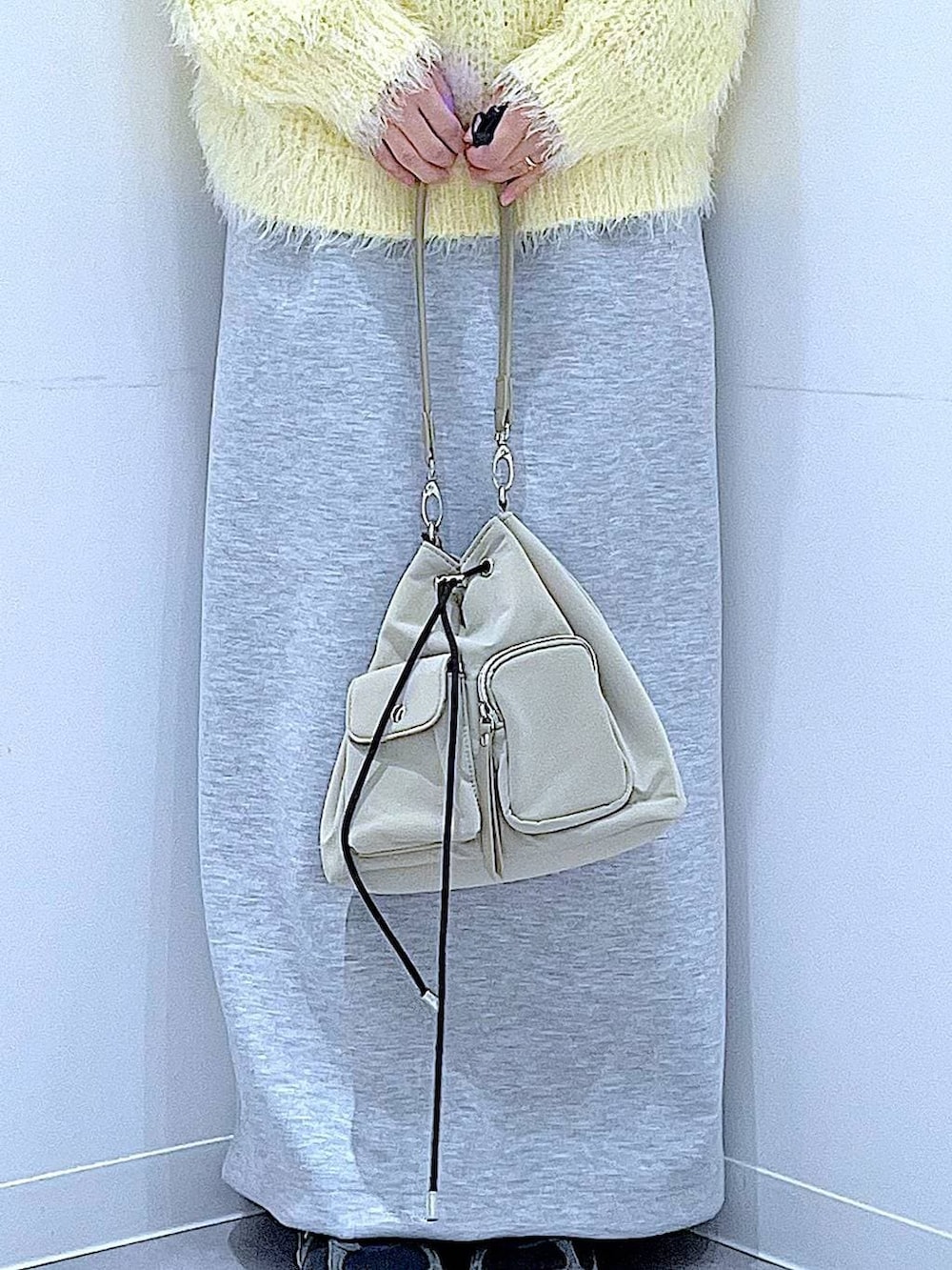 イエロー系のニット/セーター、グレー系のスカート、パープル系のバレッタ/ヘアクリップを着用したレディースの冬コーディネートの9枚目の写真