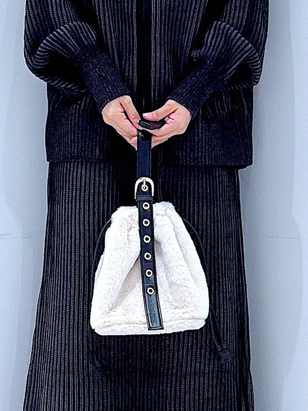 ホワイト系のハンドバッグ、ブラック系のスカート、ブラック系のニット/セーターを着用したレディースの秋コーディネートの9枚目の写真