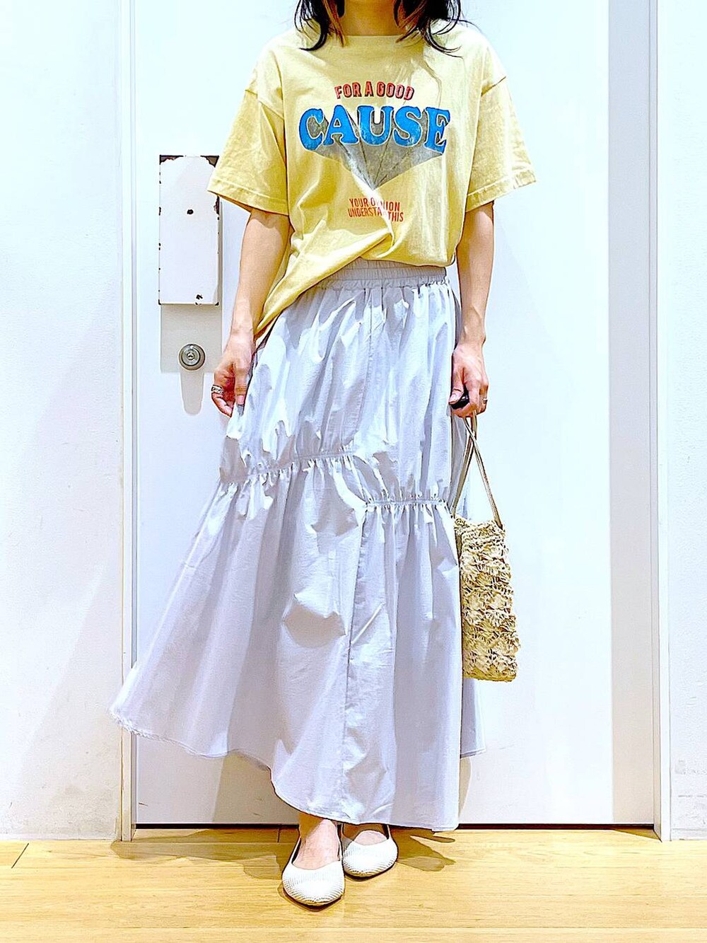 ブルー系のスカート、ホワイト系のパンプス、ベージュ系のショルダーバッグを着用したレディースの春コーディネートの6枚目の写真