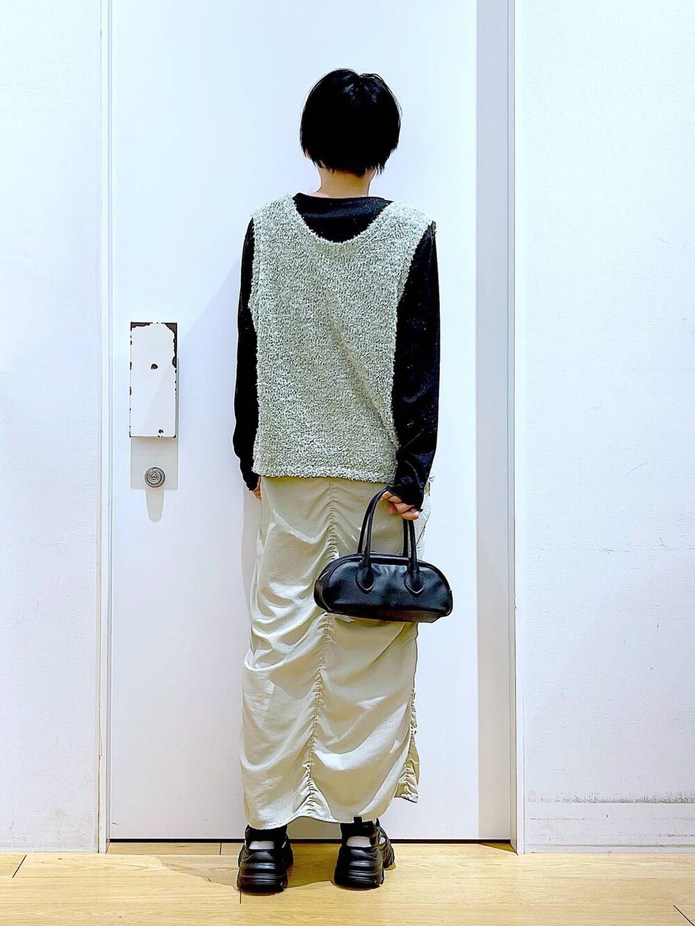 ベージュ系のスカート、ブラック系のボストンバッグ、ブラック系のTシャツ/カットソーを着用したレディースの春コーディネートの5枚目の写真