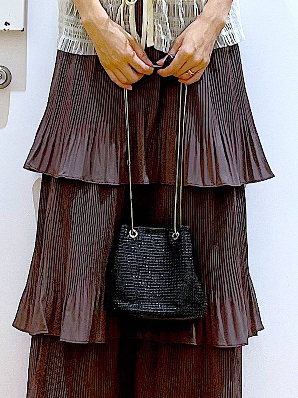 ブラウン系のスカート、ブラック系のサンダル、ホワイト系のカーディガン/ボレロを着用したレディースの夏コーディネートの9枚目の写真