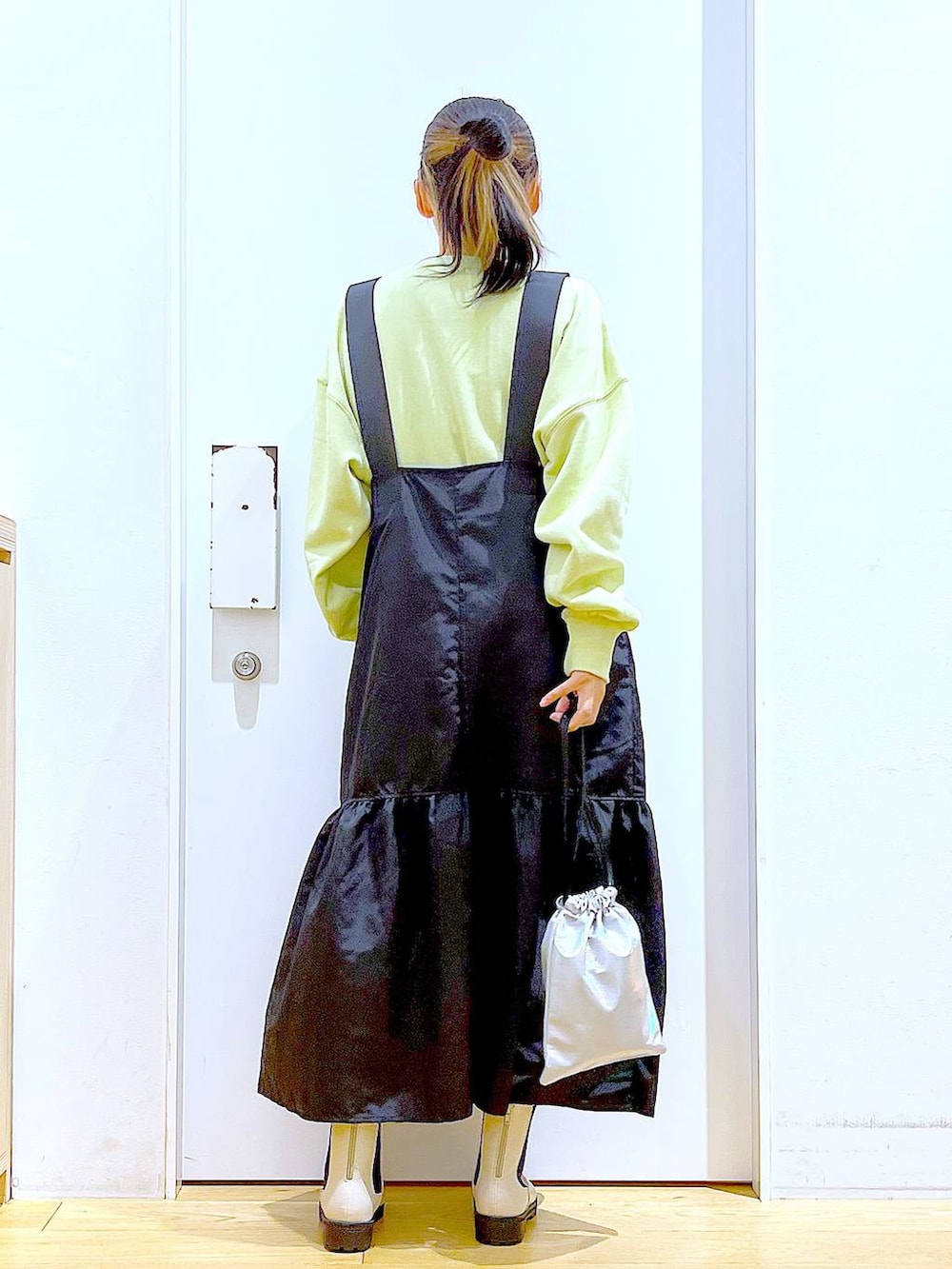 イエロー系のスウェット、ベージュ系のブーツ、その他のショルダーバッグを着用したレディースの冬コーディネートの5枚目の写真