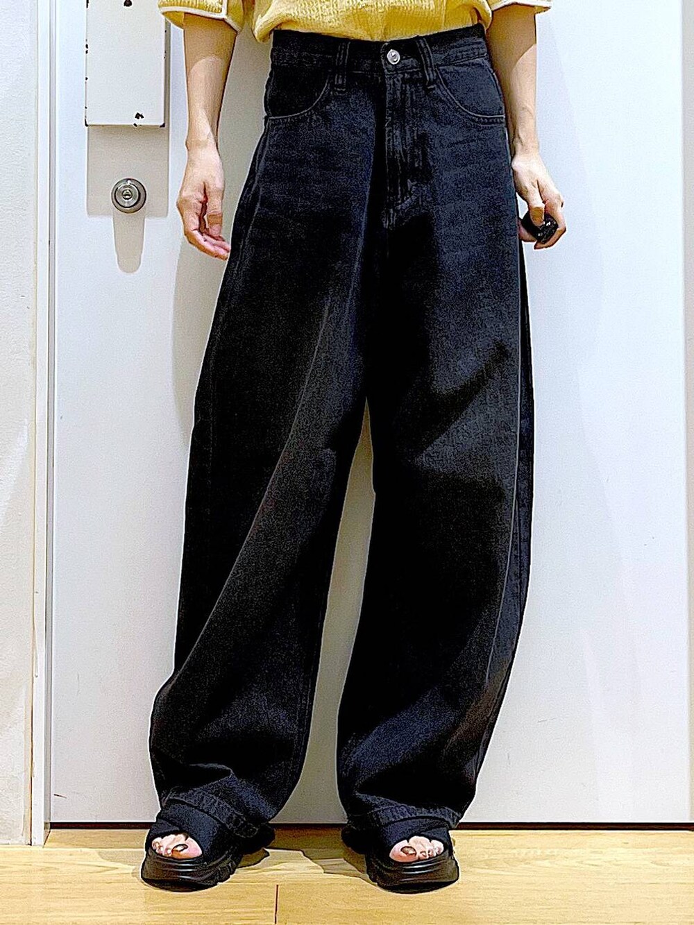 ブラック系のサンダル、ブラック系のバックパック/リュック、ブラック系のデニムパンツを着用したレディースの夏コーディネートの8枚目の写真