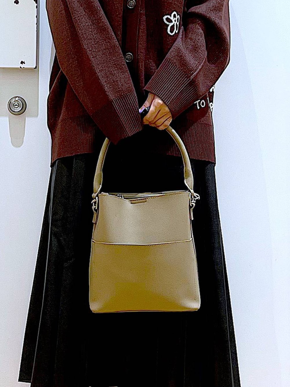 ブラック系のパンプス、ブラック系のスカート、ベージュ系のショルダーバッグを着用したレディースの秋コーディネートの9枚目の写真