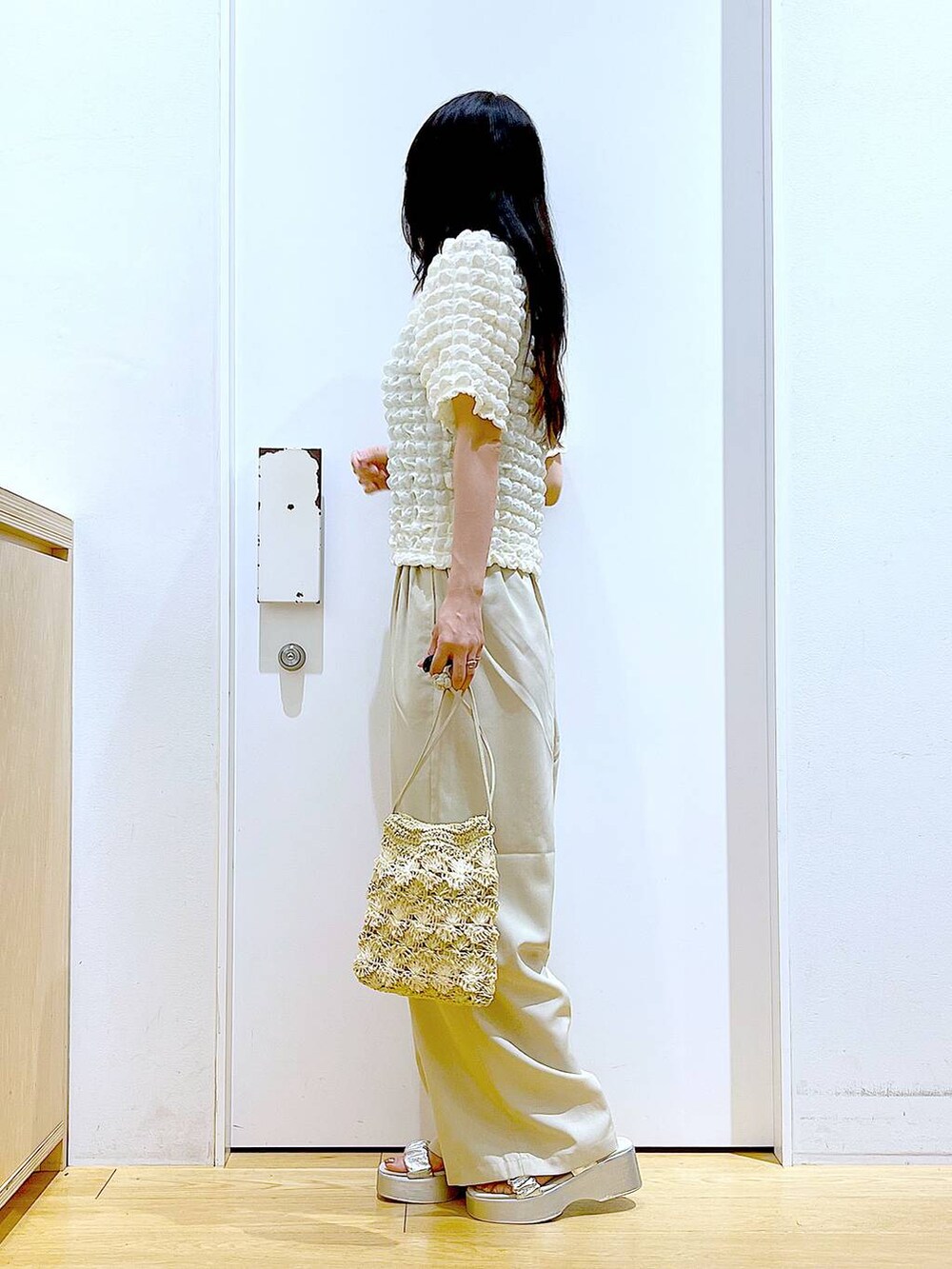 シルバー系のサンダル、ベージュ系のショルダーバッグ、ベージュ系のTシャツ/カットソーを着用したレディースの夏コーディネートの3枚目の写真