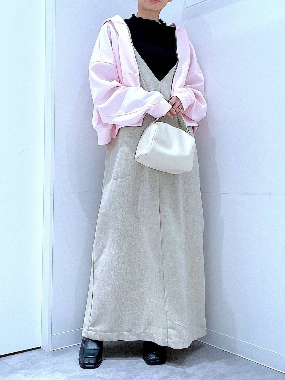 ブラック系のブーツ、ベージュ系のジャンパースカート、ブラック系のTシャツ/カットソーを着用したレディースの冬コーディネートの6枚目の写真