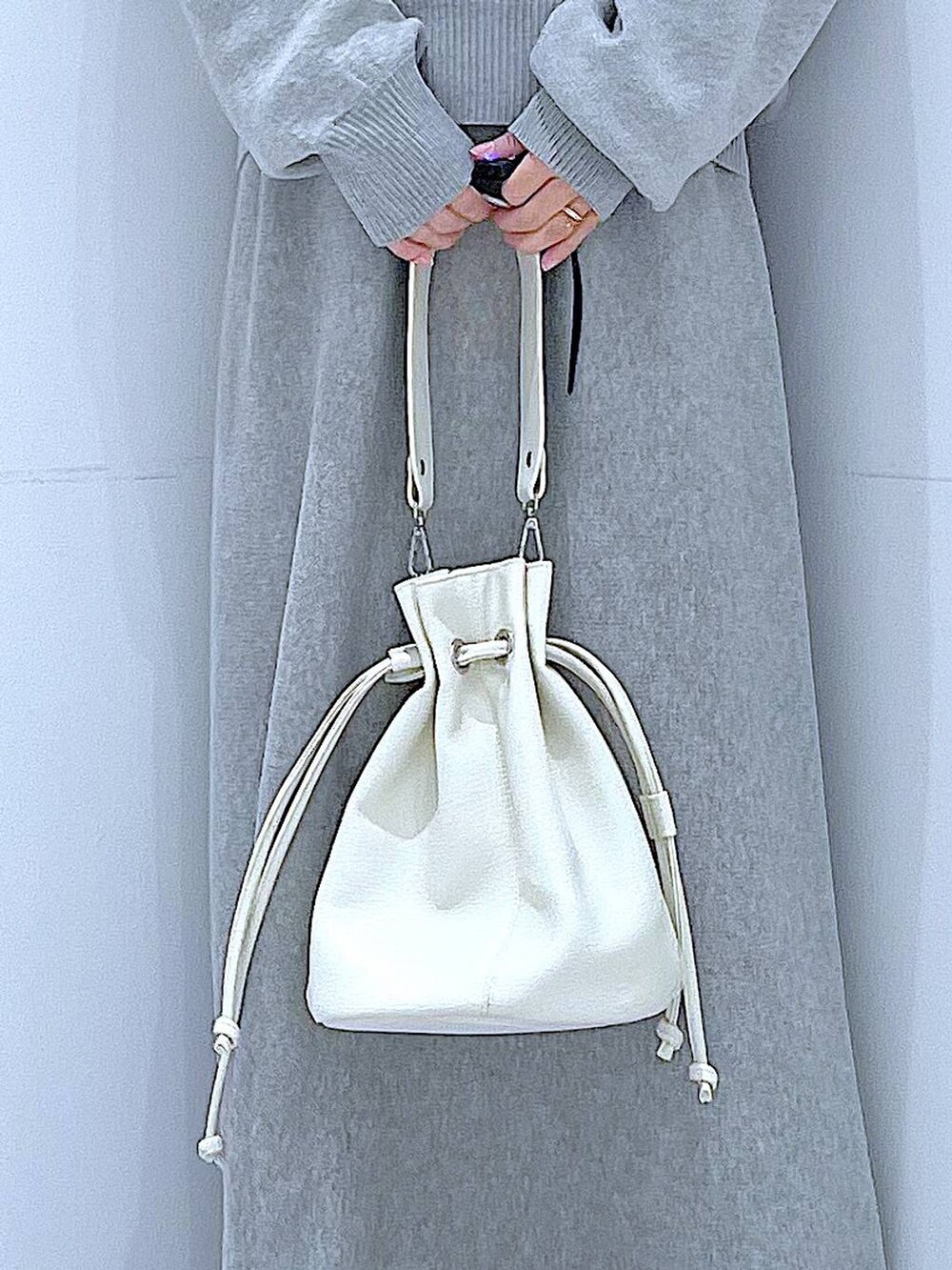 ブラック系のTシャツ/カットソー、グレー系のスカート、ホワイト系のショルダーバッグを着用したレディースの春コーディネートの9枚目の写真