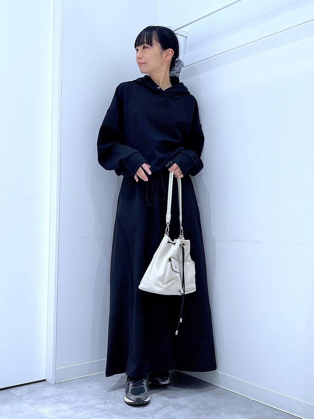 ベージュ系のショルダーバッグ、ブラック系のスウェット、ブラック系のスカートを着用したレディースの春コーディネートの2枚目の写真