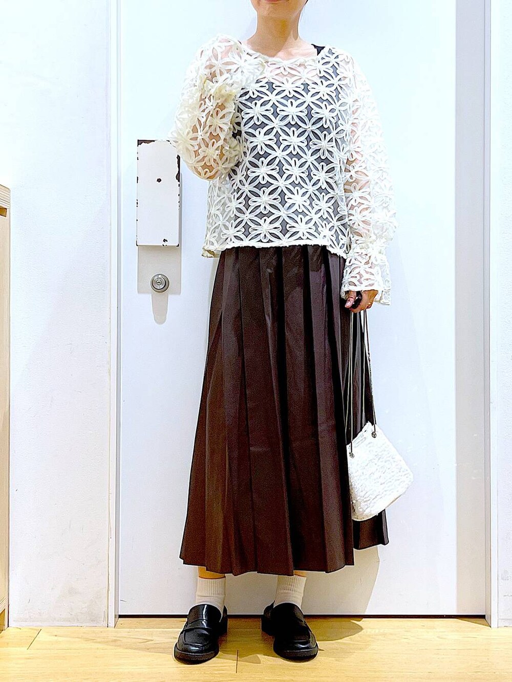 ホワイト系のショルダーバッグ、ブラック系のローファー、ベージュ系のシャツ/ブラウスを着用したレディースの秋コーディネートの6枚目の写真