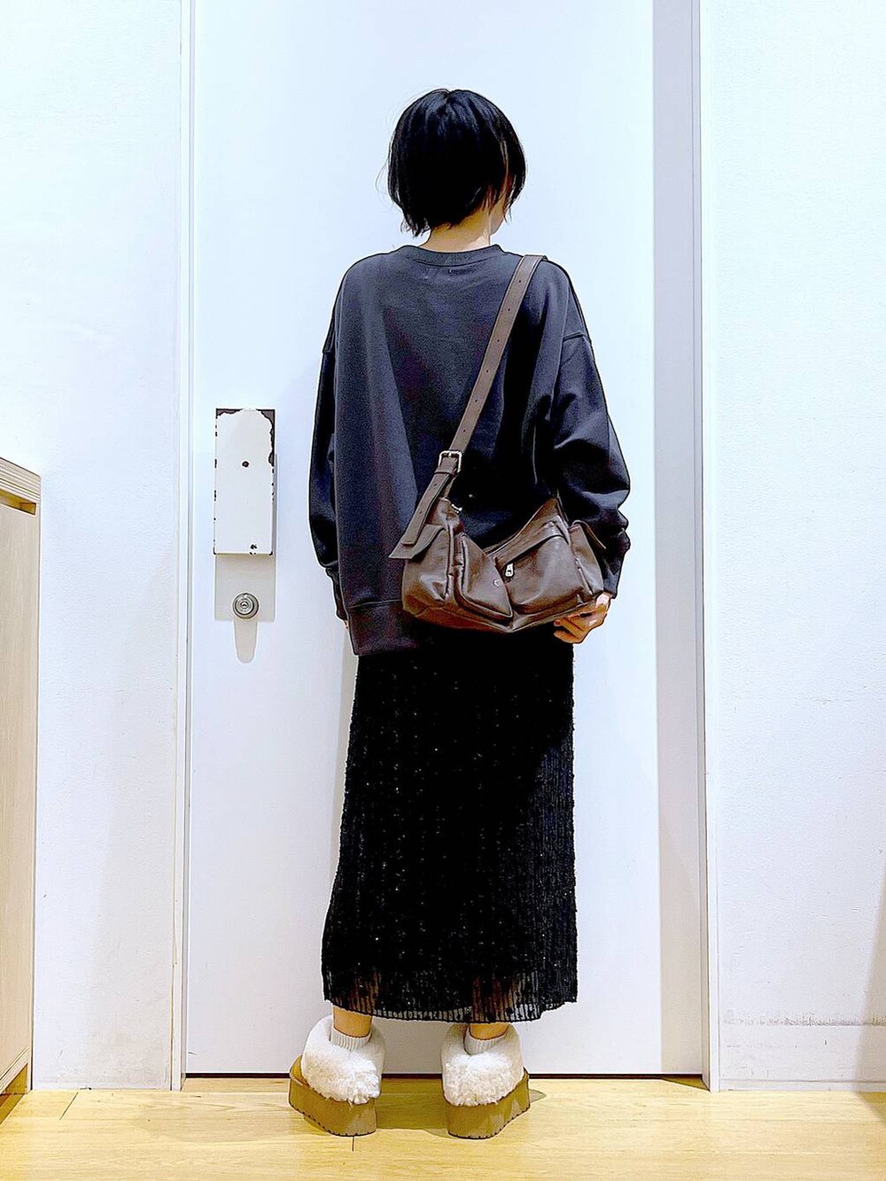 ベージュ系のスリッポン、ブラック系のスカート、グレー系のスウェットを着用したレディースの秋コーディネートの5枚目の写真