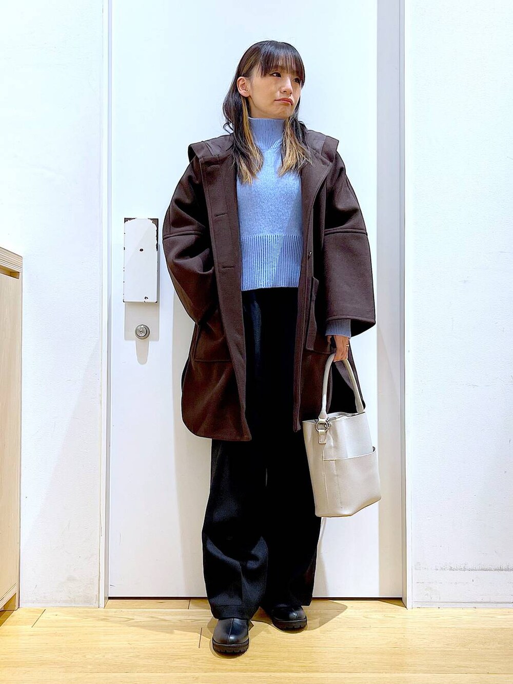 ブラウン系のその他アウター、グレー系のショルダーバッグ、ブラック系のブーツを着用したレディースの冬コーディネートの2枚目の写真