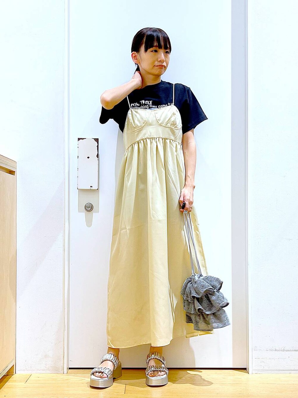 シルバー系のショルダーバッグ、シルバー系のサンダル、ブラック系のTシャツ/カットソーを着用したレディースの夏コーディネートの2枚目の写真