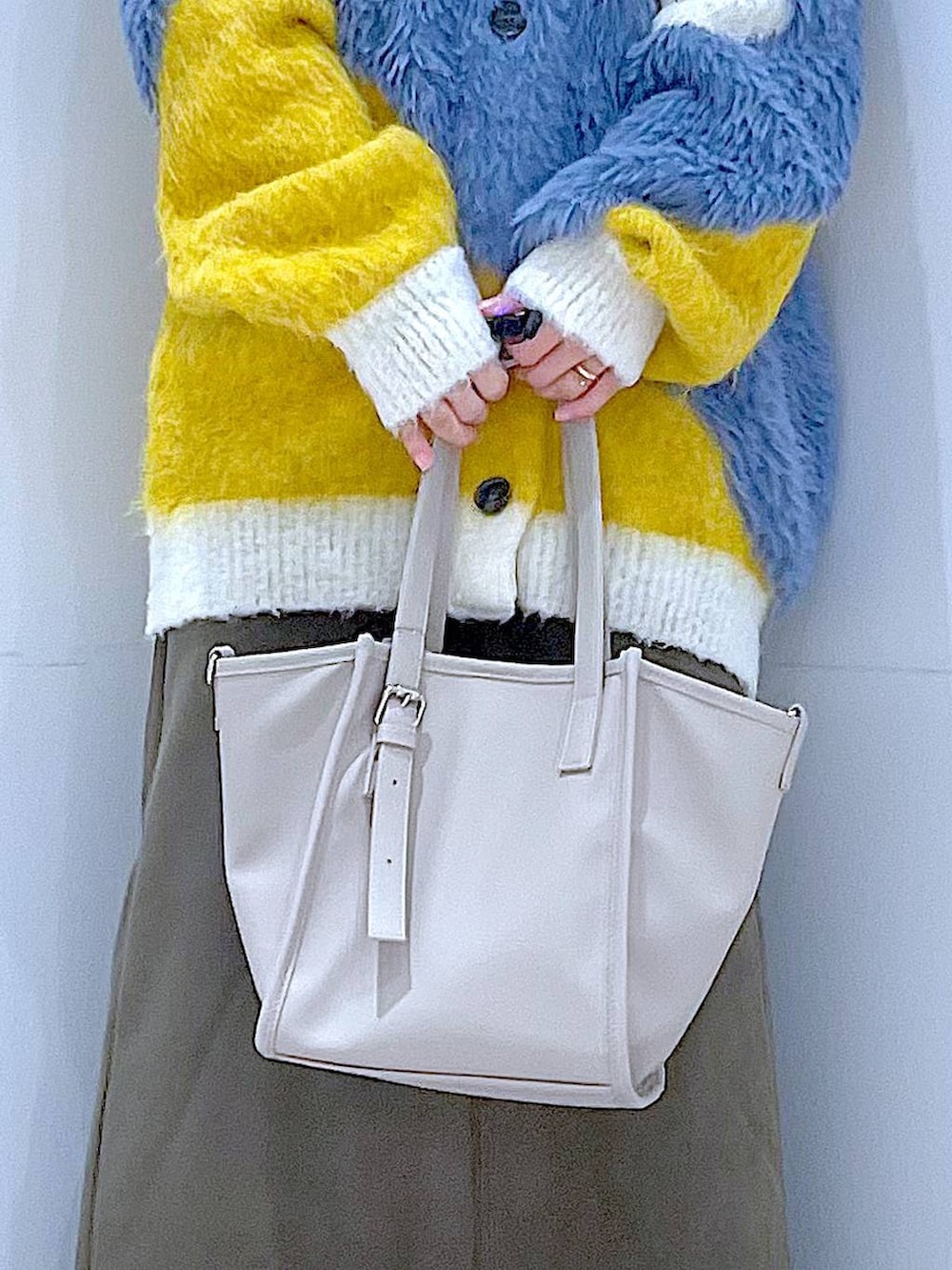 イエロー系のカーディガン/ボレロ、ブラック系のブーツ、グリーン系のスカートを着用したレディースの冬コーディネートの9枚目の写真