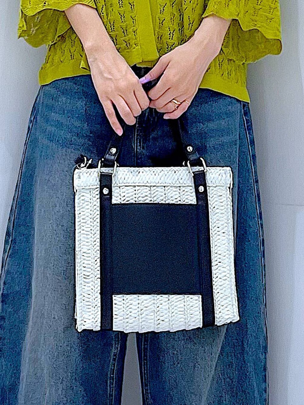 ブルー系のデニムパンツ、ブラック系のスニーカー、ホワイト系のショルダーバッグを着用したレディースの春コーディネートの9枚目の写真