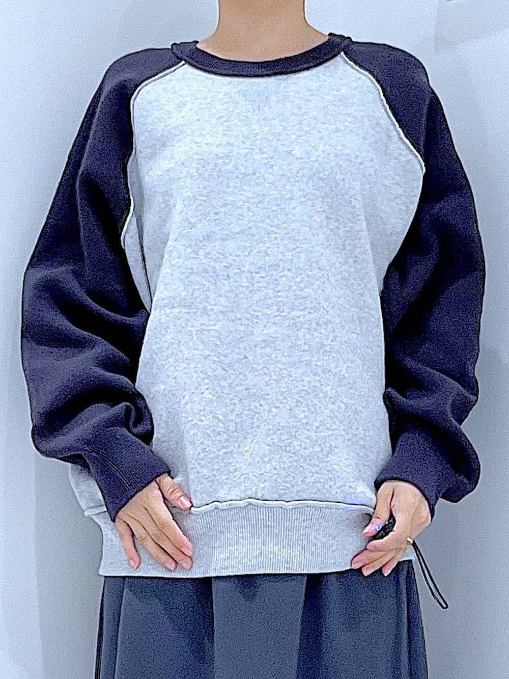 グレー系のスカート、グレー系のニット/セーター、ブラック系のブーツを着用したレディースの秋コーディネートの7枚目の写真