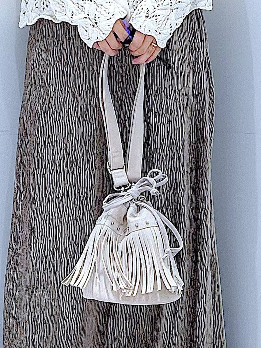 ブラック系のブーツ、ホワイト系のショルダーバッグ、ベージュ系のカーディガン/ボレロを着用したレディースの冬コーディネートの9枚目の写真