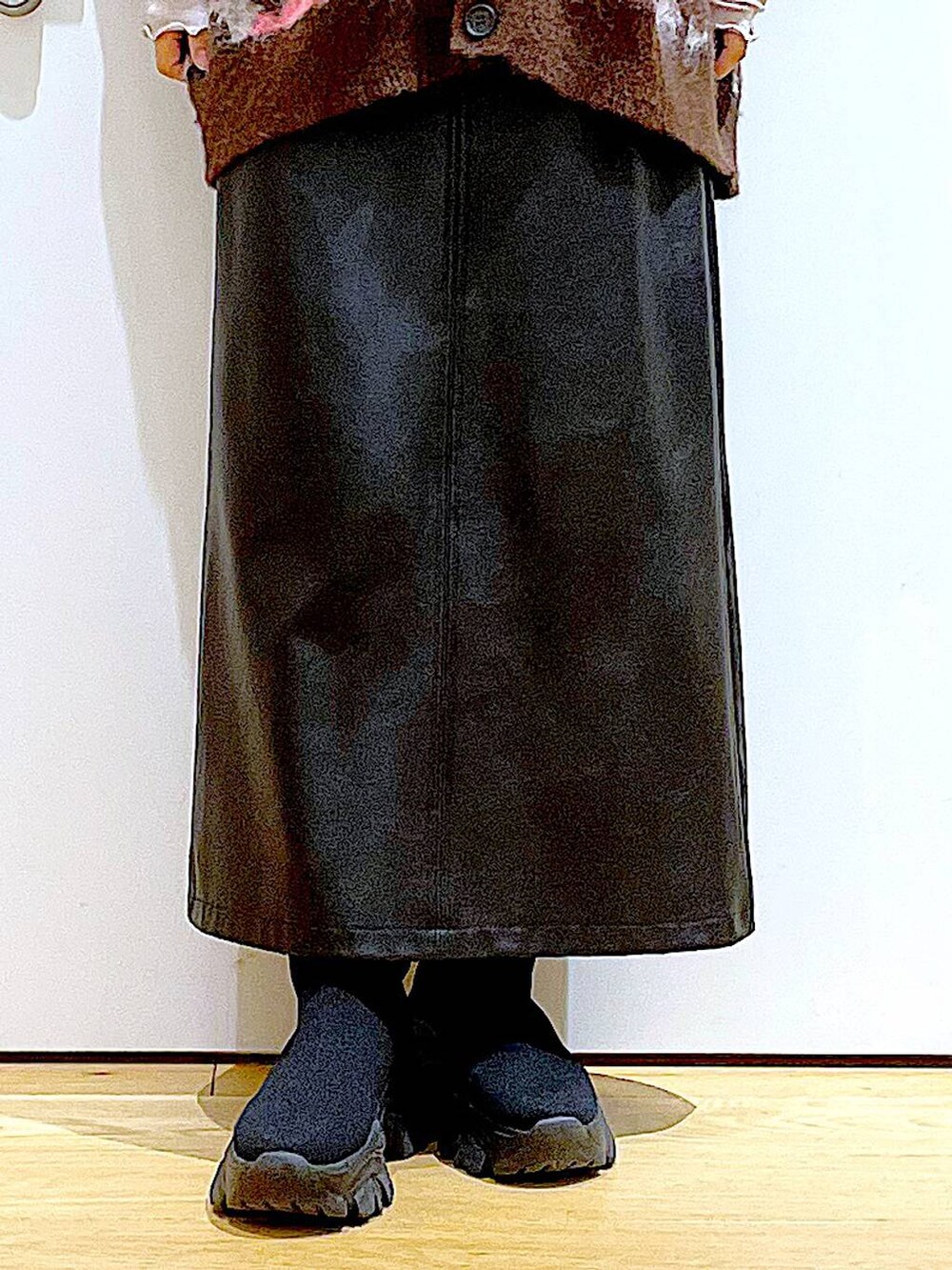 グレー系のTシャツ/カットソー、ブラック系のブーツ、ブラック系のスカートを着用したレディースの冬コーディネートの8枚目の写真